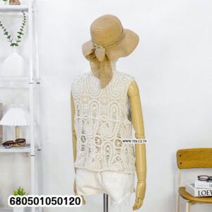 Women’s crochet vest top styled with shorts, straw hat, and books on side table