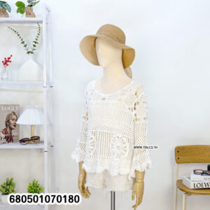 Boho-style long sleeve crochet blouse in cream and white, styled with straw hat and white shorts