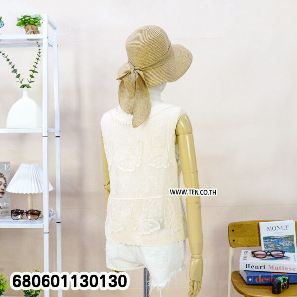 Casual white lace vest for women styled with a straw hat and white denim shorts