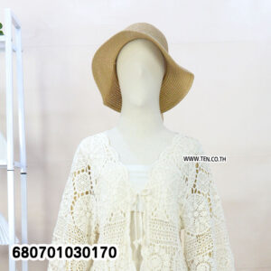 Woman’s boho crochet lace summer cardigan in cream, styled with shorts and straw hat.