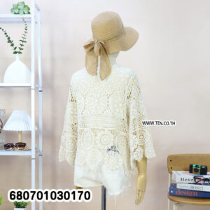Woman’s boho crochet lace summer cardigan in cream, styled with shorts and straw hat.