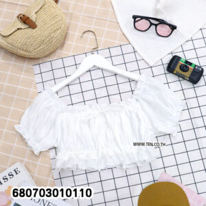 Two identical puff sleeve crop tops, one white and one cream, laid flat on a checkered background with summer accessories.