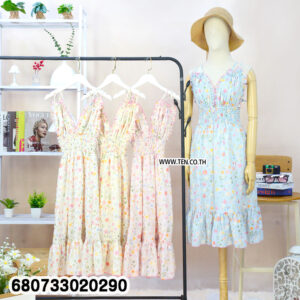 Group of pastel floral summer dresses on hanger beside mannequin styled with hat