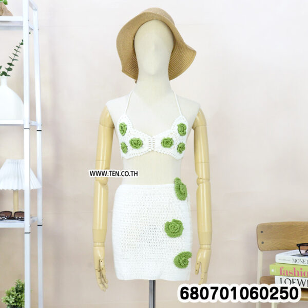 Boho crochet set with top and mini skirt on mannequin and rack, styled with beach accessories