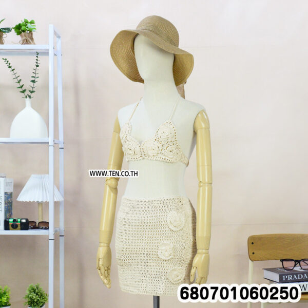 Boho crochet set with top and mini skirt on mannequin and rack, styled with beach accessories