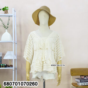 Casual white crochet lace blouse paired with shorts, displayed in a minimal setting.