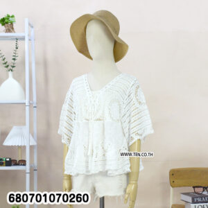 Casual white crochet lace blouse paired with shorts, displayed in a minimal setting.